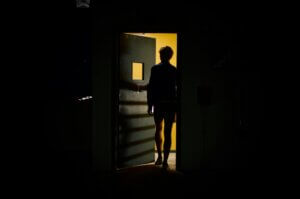 Figura sulla soglia di una porta illuminata — corso live sul sabotatore interno